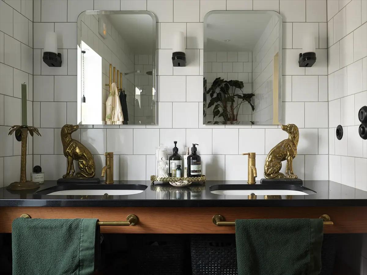 Bathroom with brass fixtures, dog figurines, and a palm-shaped candleholder