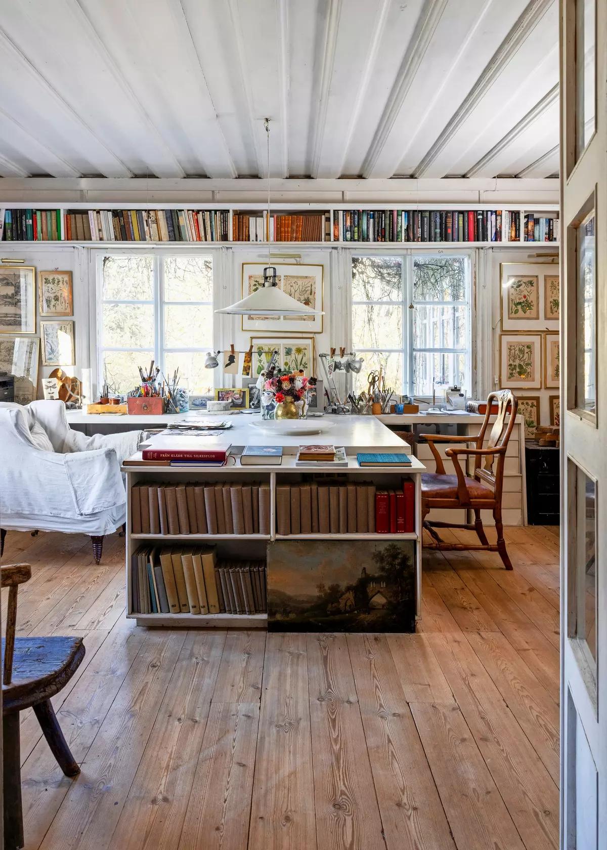 Artist’s workspace with bookshelves reaching the ceiling