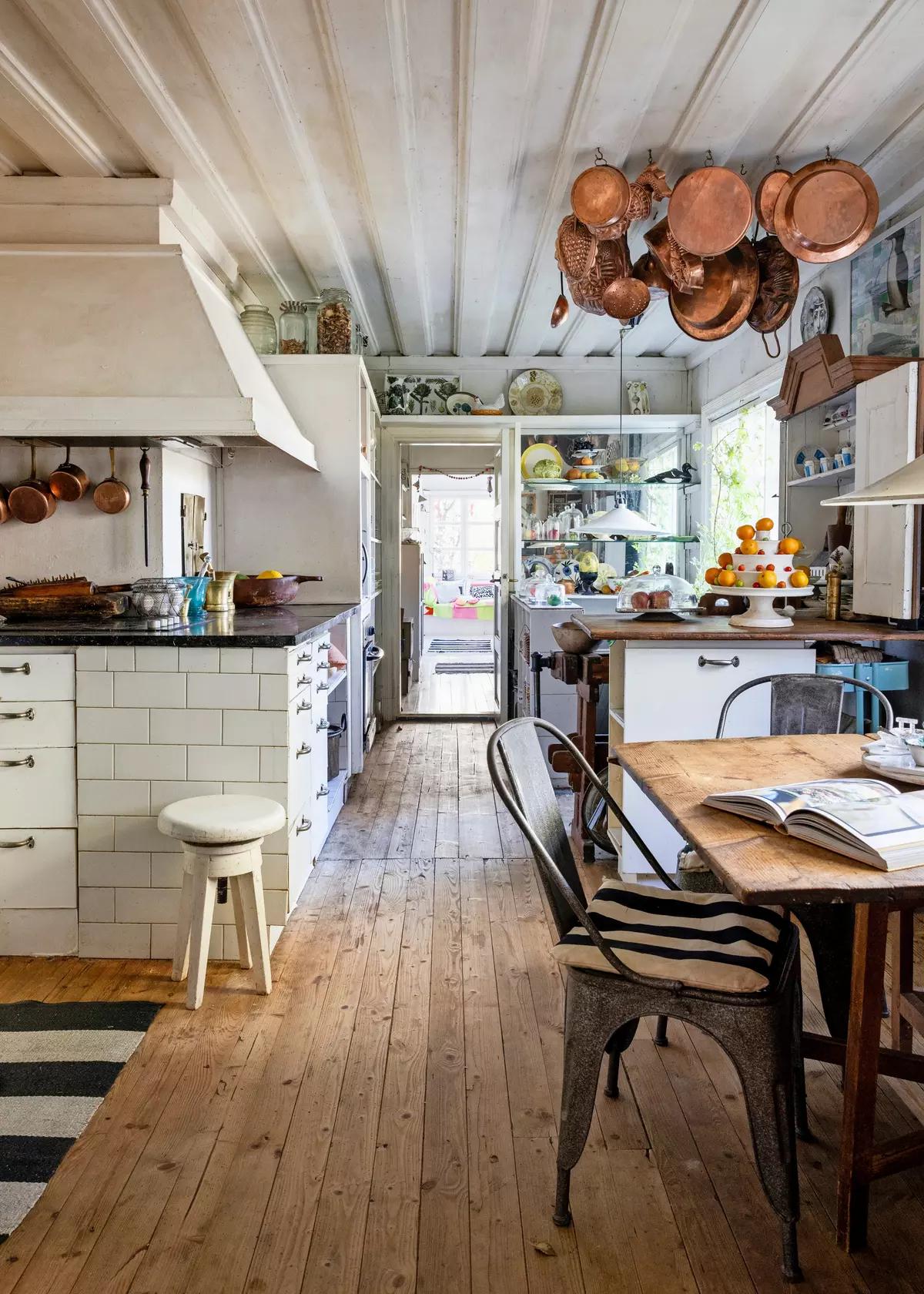Kitchen with hanging copper cookware and wooden cabinets