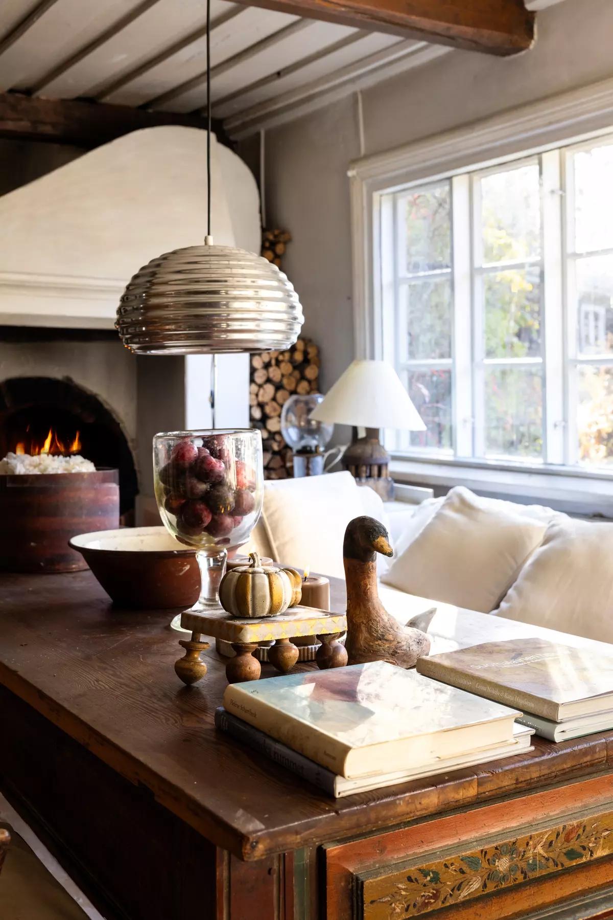 Antique writing desk with books and a wood-burning stove in the background