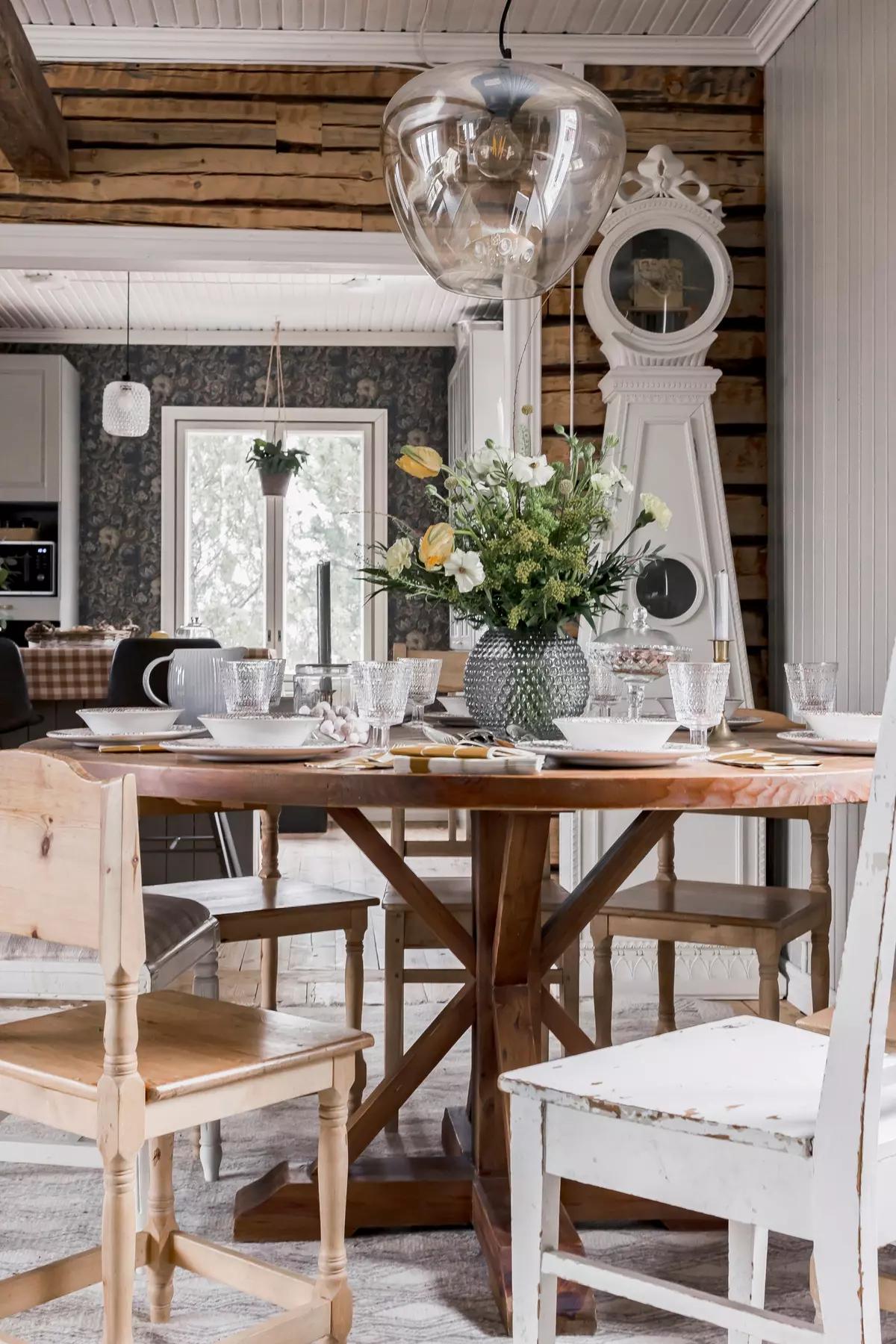 Wooden chairs and dining table with flowers in a vase