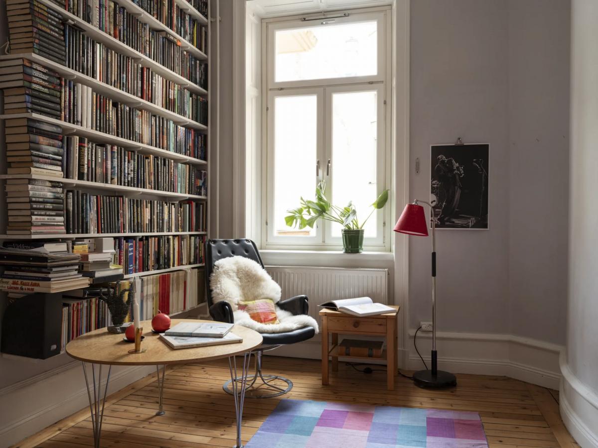 Cozy home library with reading chair in Södermalm apartment