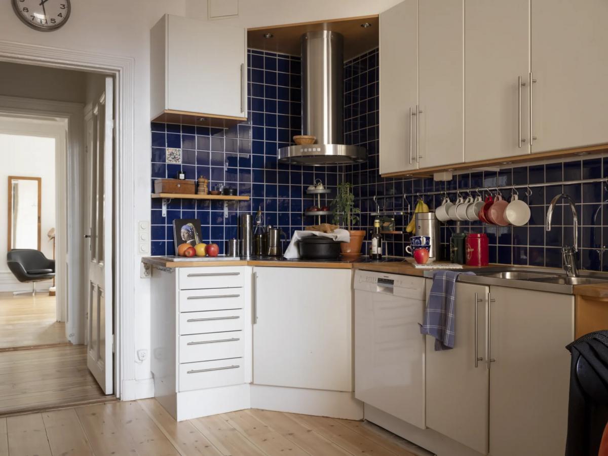 Scandinavian kitchen with navy backsplash and vintage white cabinets