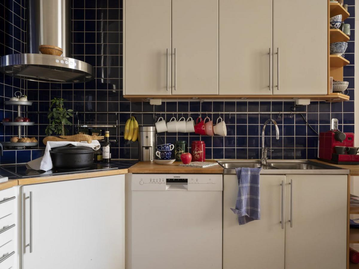 Stylish deep blue backsplash in Stockholm apartment kitchen