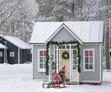 Small grey cottage decorated with garlands and a wreath