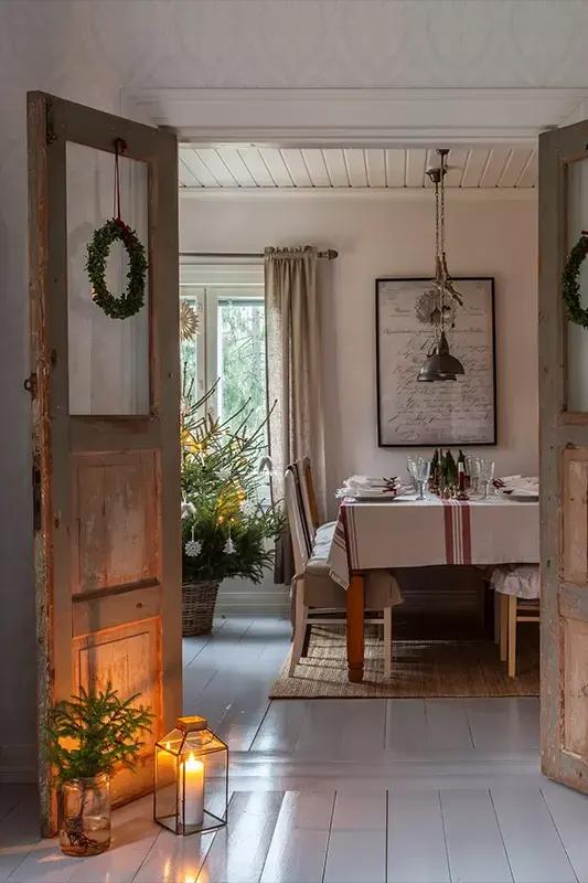 Doorway with a Christmas wreath leading into a dining room with a set table