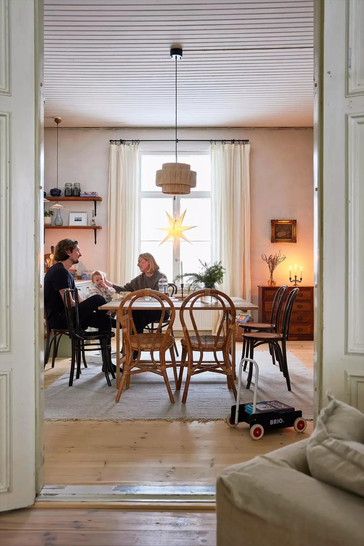 Young Finnish family sitting at a wooden dining table