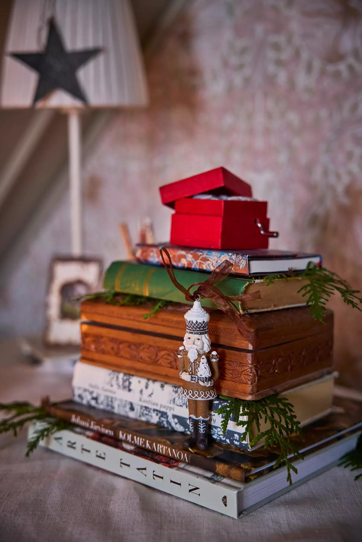 Stack of vintage and modern books decorated with fir sprigs