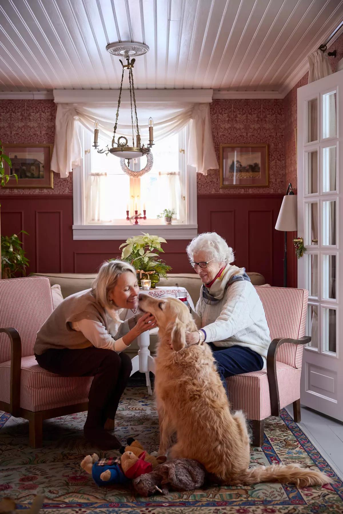 Ulla Rantakari in the living room with her mother and their golden retriever