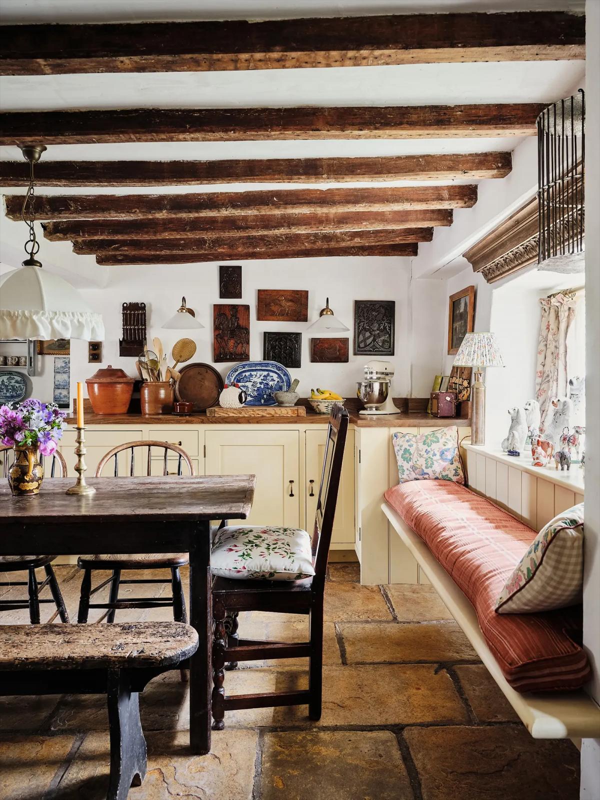 Kitchen with rough wooden table, rustic chairs and exposed ceiling beams