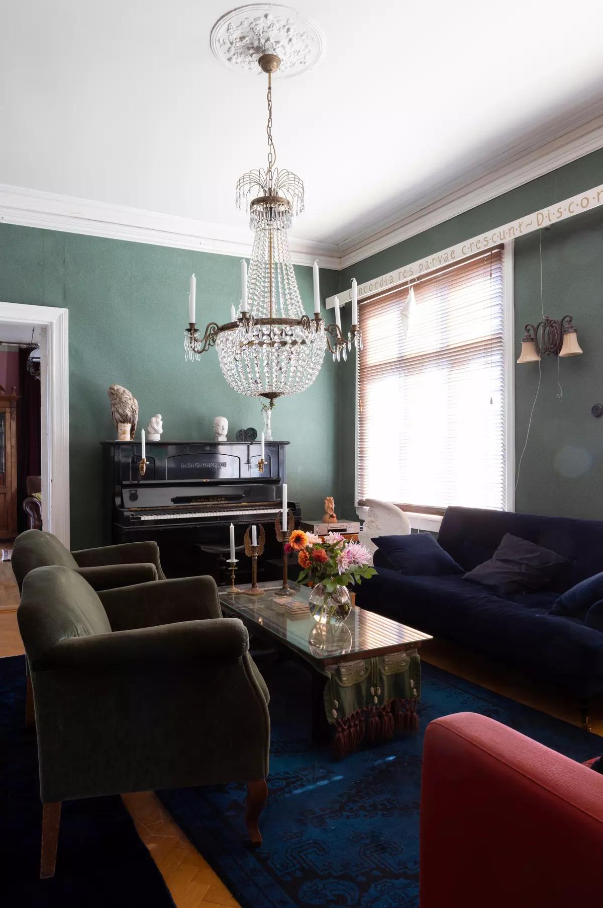Antique piano in the living room with green walls