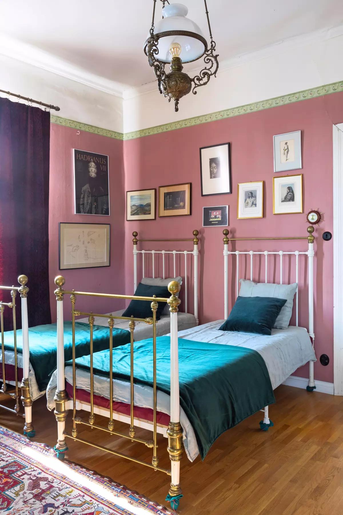 Two vintage single beds in a room with pink walls