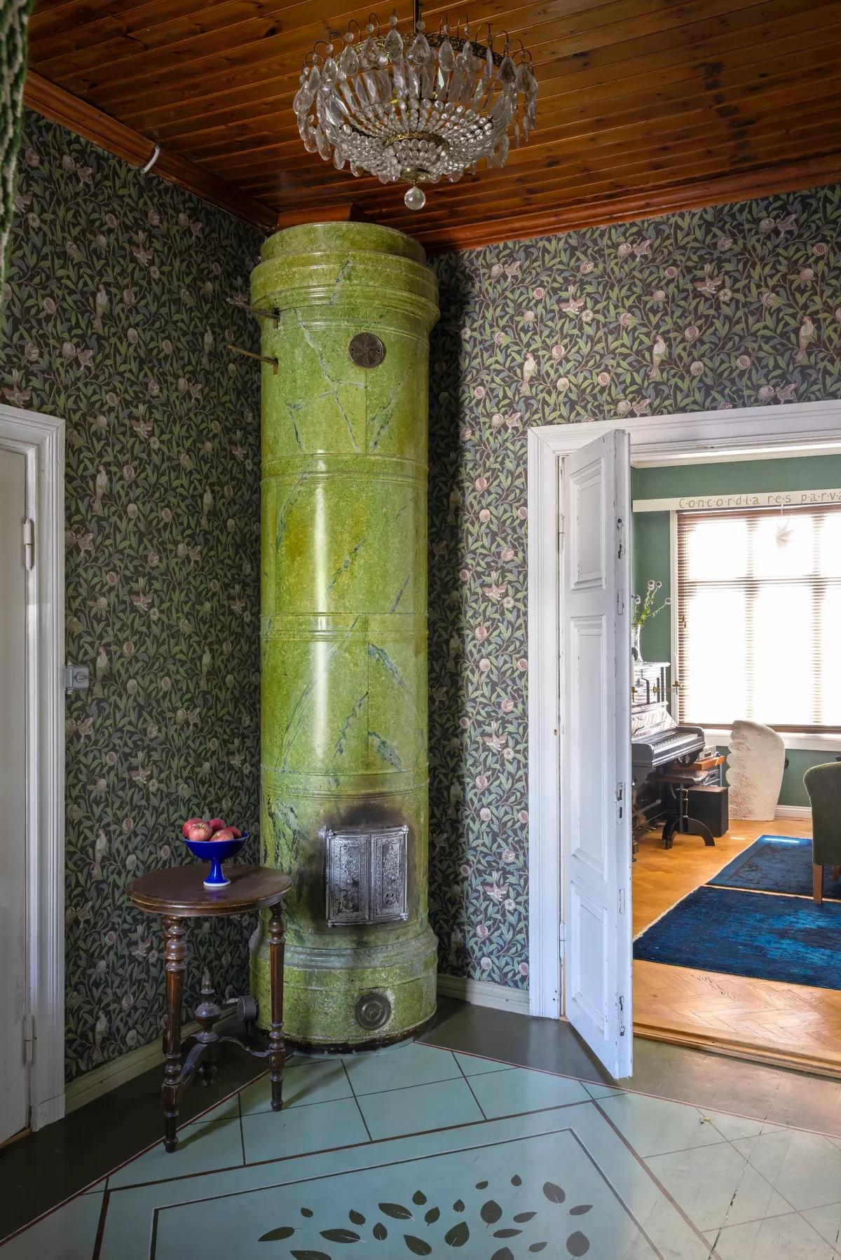 Old green stove in the corner with William Morris wallpaper
